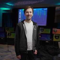 A person standing in front of a large screen

Description automatically generated