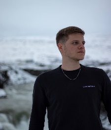 A person standing in front of a body of water

Description automatically generated